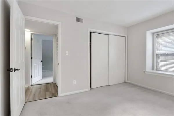 an empty room with windows and closet
