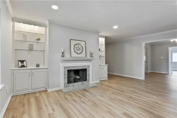 a view of empty room with wooden floor and fireplace