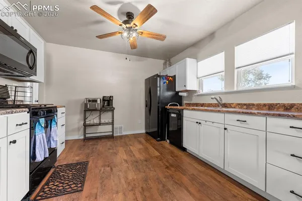 a kitchen with granite countertop a refrigerator stove top oven and sink