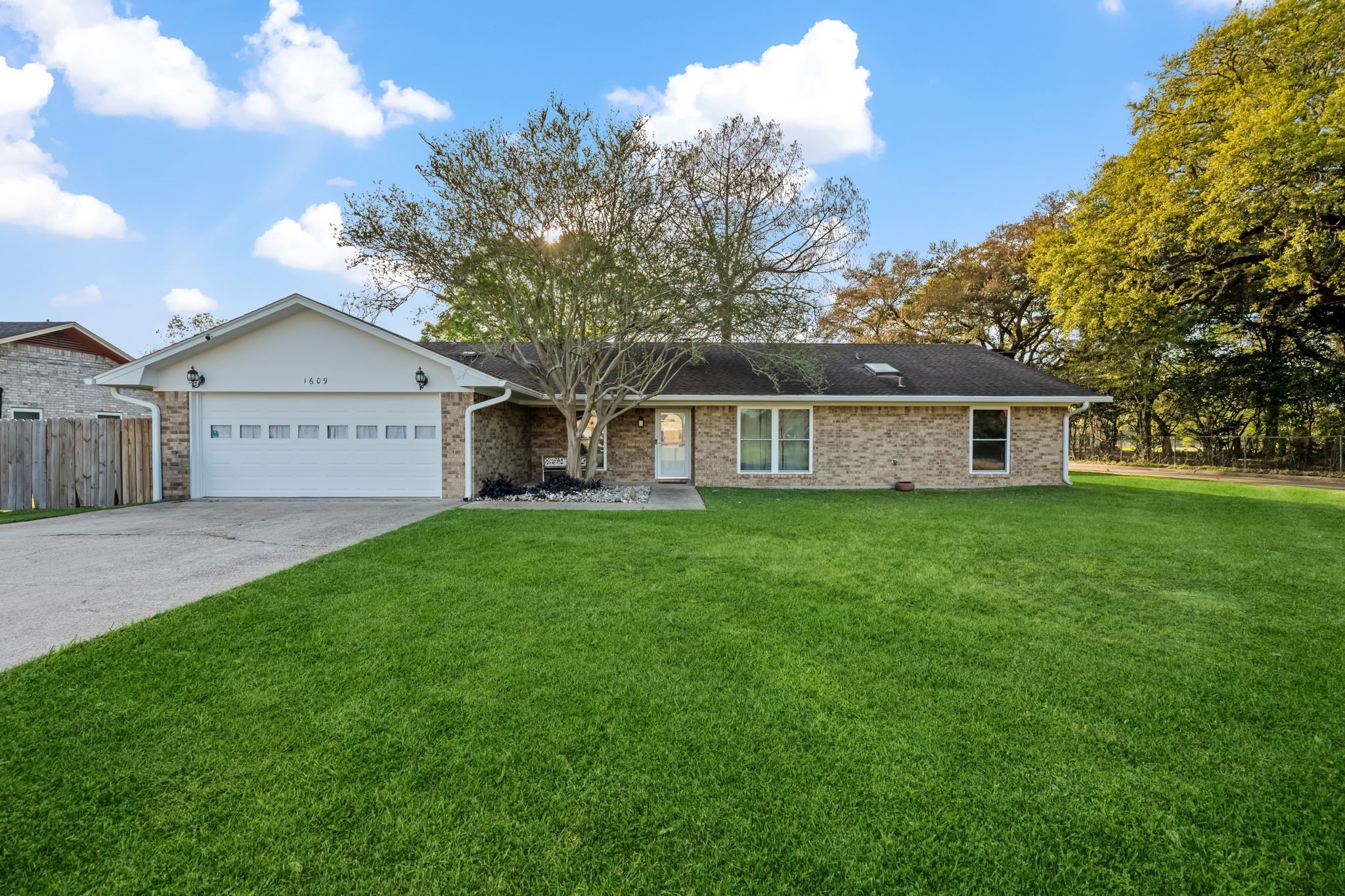 a view of a house with a big yard and large tree