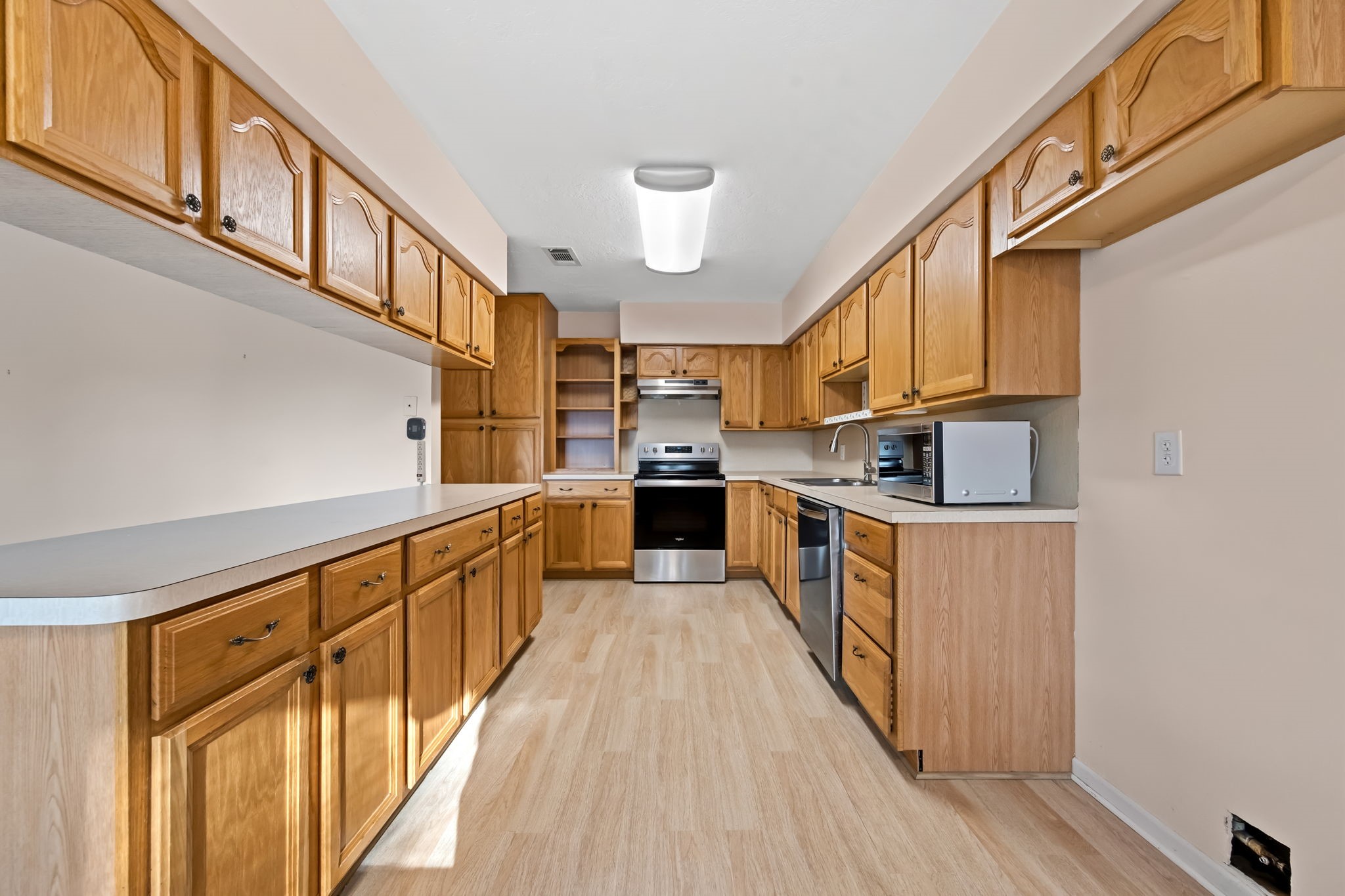 1609 Bowie Street Liberty, TX 77575 - Photo 6 of 24 a kitchen with stainless steel appliances granite countertop lots of counter top space and wooden floor