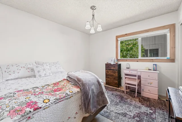 a bedroom with a bed dresser and a window