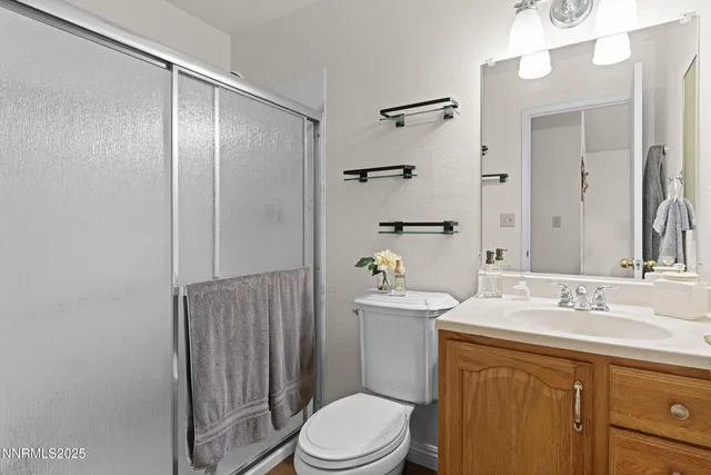 a bathroom with a sink a toilet a mirror and shower