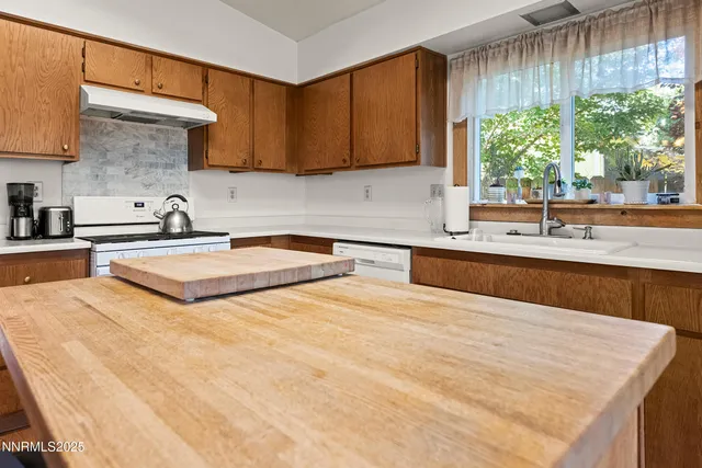 a kitchen with kitchen island granite countertop a sink a counter top space and cabinets