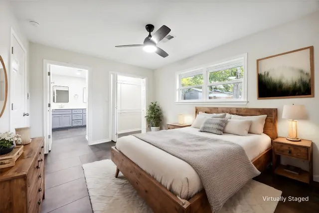 a spacious bedroom with a bed and a flat screen tv