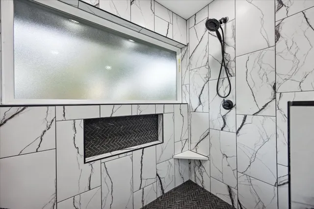 a view of entryway with a white wall and a chandelier