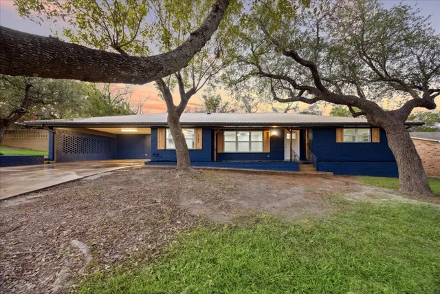 a view of a house with a yard and tree s