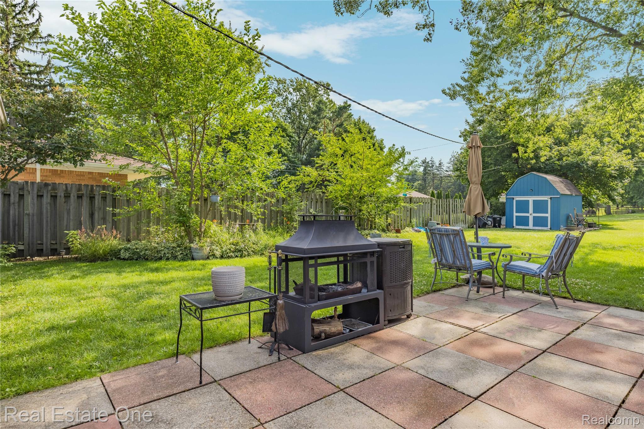 2810 Walbridge Drive Rochester, MI 48307 - Photo 43 of 58 Spacious backyard featuring a multi-tone paver patio, lush green lawn, mature trees, and a wooden privacy fence