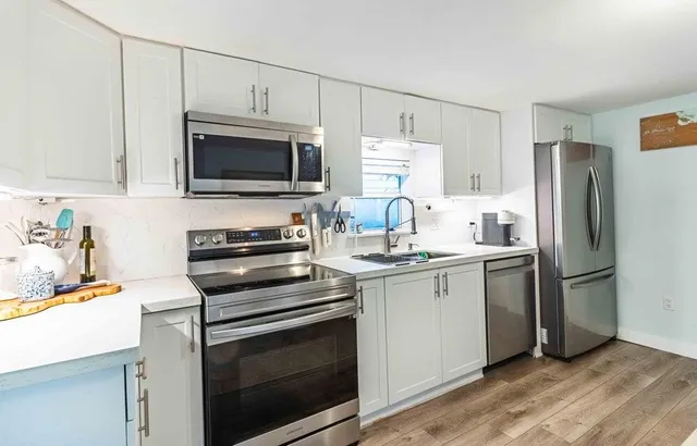 a kitchen with stainless steel appliances a stove microwave and refrigerator