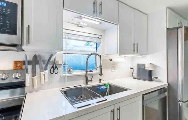 a kitchen with a sink a stove and cabinets