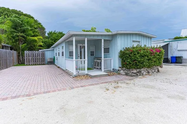 a view of a house with a small yard and wooden fence
