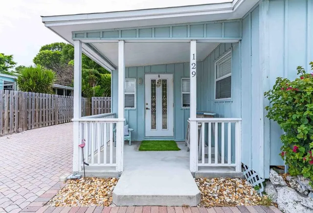 a view of a house with a small yard and wooden fence