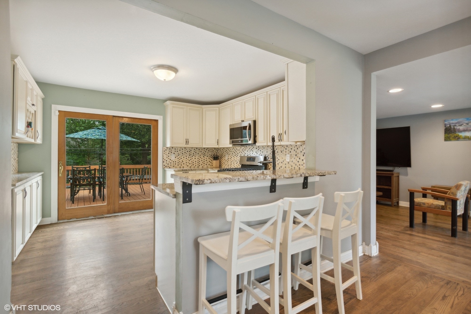 210 Seabury Road Bolingbrook, IL 60440 - Photo 2 of 14 a kitchen with stainless steel appliances granite countertop a stove top oven a sink dishwasher a dining table and chairs with wooden floor