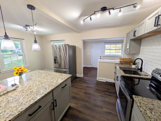a kitchen with stainless steel appliances granite countertop a sink stove and refrigerator