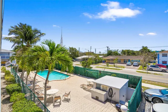a view of a patio with a table and chairs under an umbrella