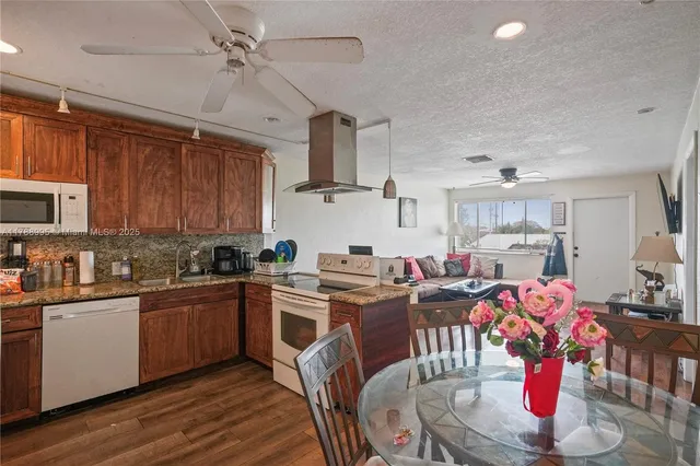 a kitchen with stainless steel appliances granite countertop a sink dishwasher and cabinets with wooden floor