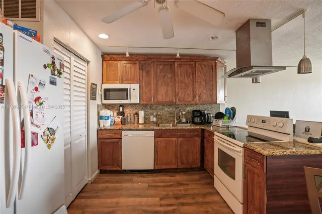 a kitchen with stainless steel appliances granite countertop a refrigerator and a stove top oven