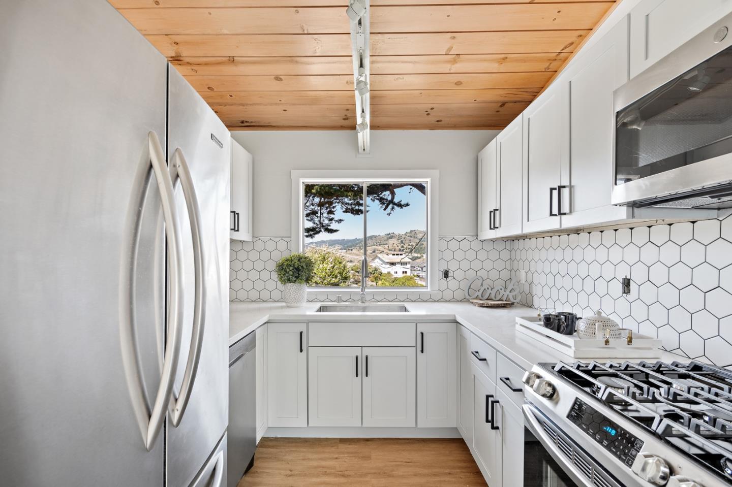 144 Kent Road Pacifica, CA 94044 - Photo 18 of 44 a kitchen with stainless steel appliances a stove a sink and a microwave