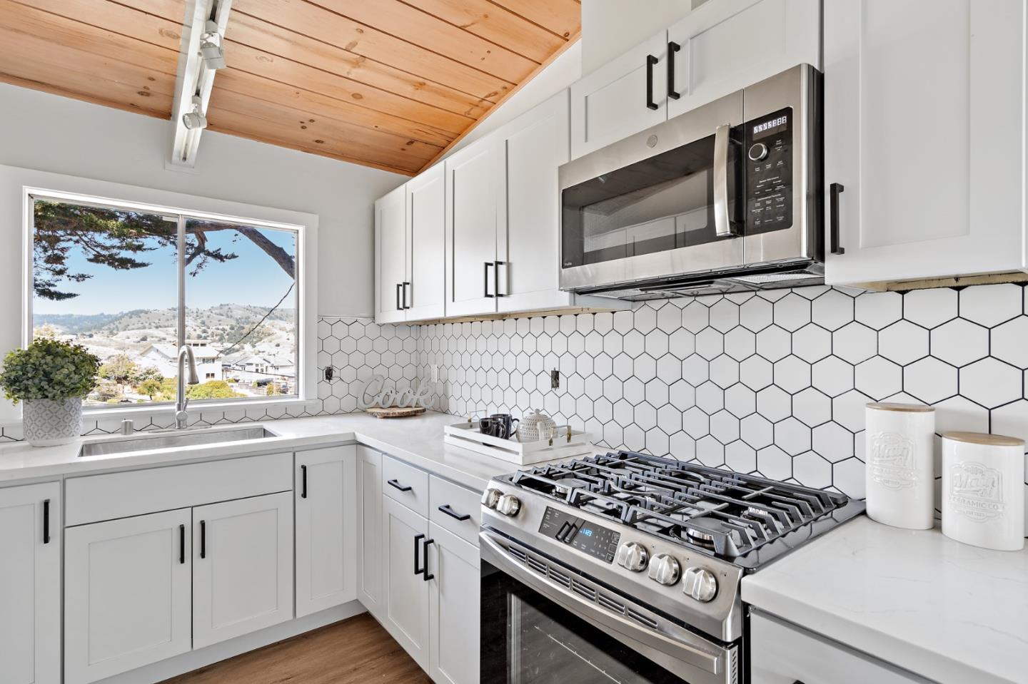 144 Kent Road Pacifica, CA 94044 - Photo 21 of 44 a kitchen with stainless steel appliances a stove a microwave sink and cabinets
