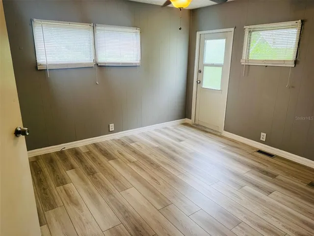 a view of empty room with wooden floor