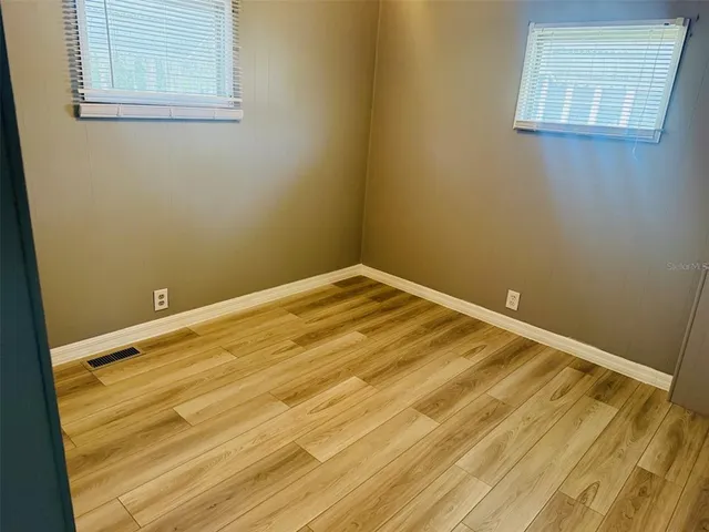 a view of a room with wooden floor and a window