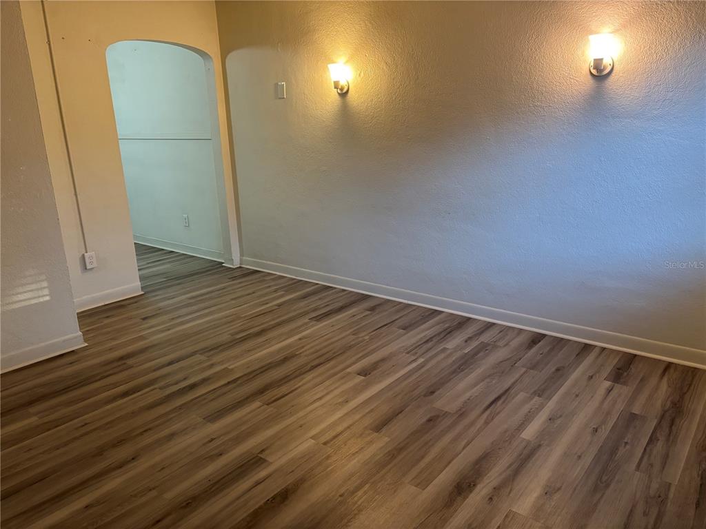 1102 Sunset Point Road, Unit 2 Clearwater, FL 33755 - Photo 2 of 17 a view of a room with wooden floor and brick walls