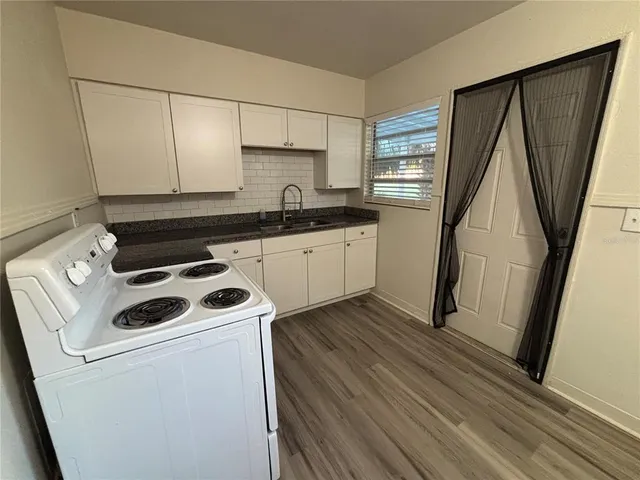 a kitchen with a sink a stove a refrigerator and cabinets