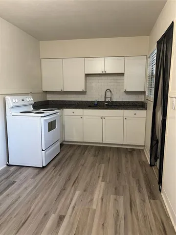 a kitchen with a sink and wooden floor