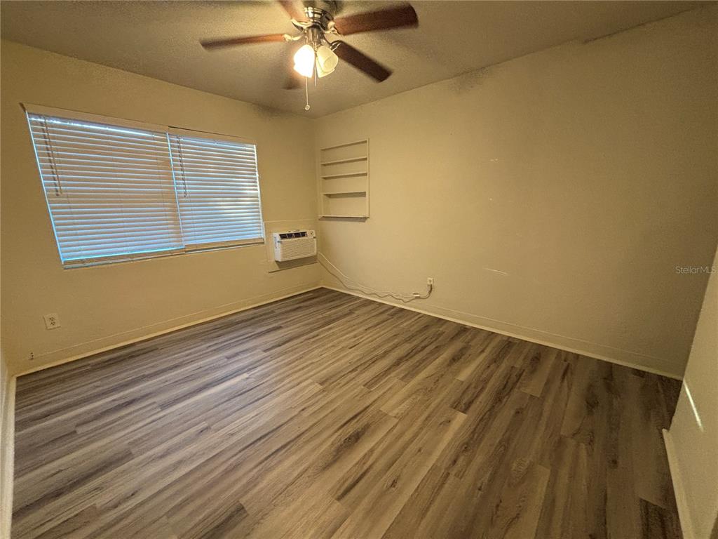 1102 Sunset Point Road, Unit 2 Clearwater, FL 33755 - Photo 9 of 17 a view of an empty room with wooden floor and a window