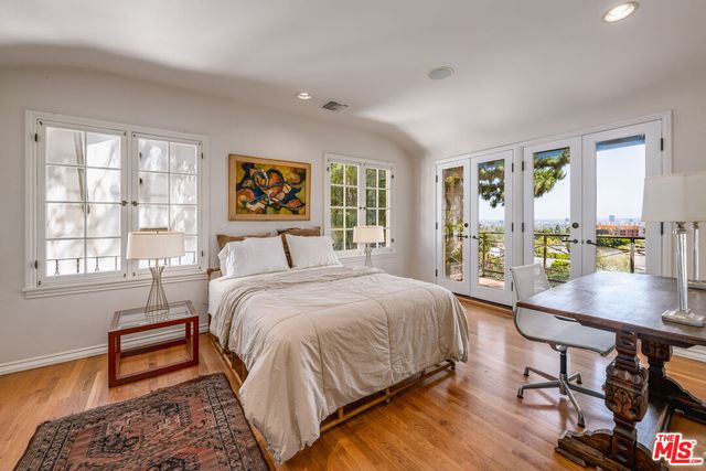 a bedroom with a bed and a table in it with window