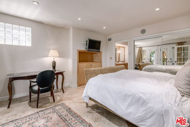 a spacious bedroom with a bed and a chair