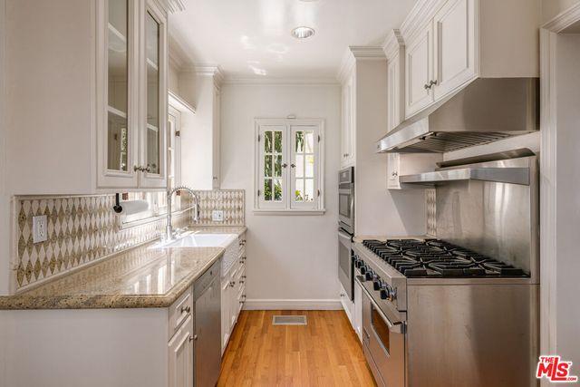 a kitchen with granite countertop a sink stove and refrigerator
