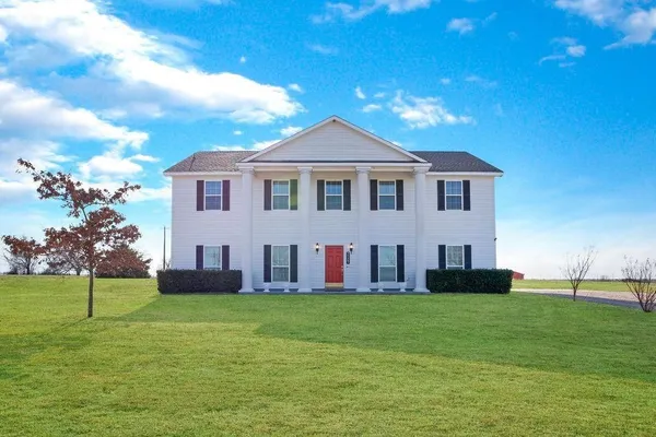 a front view of house with yard and green space