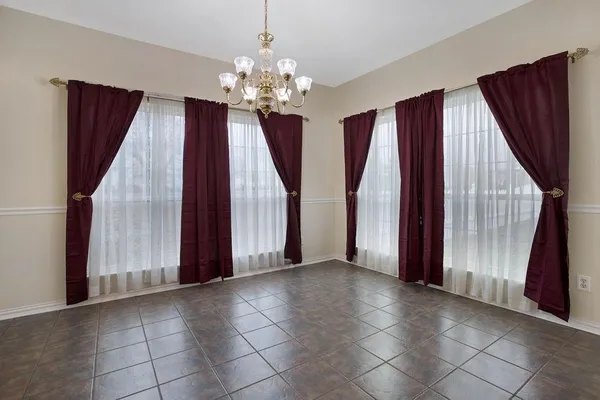 a view of a livingroom with a fireplace chandelier and windows