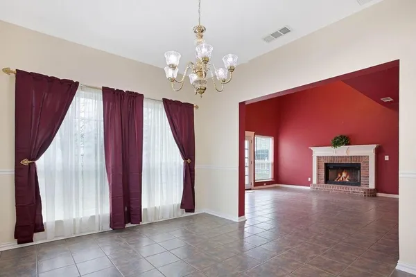 a view of an empty room with a fireplace and a window
