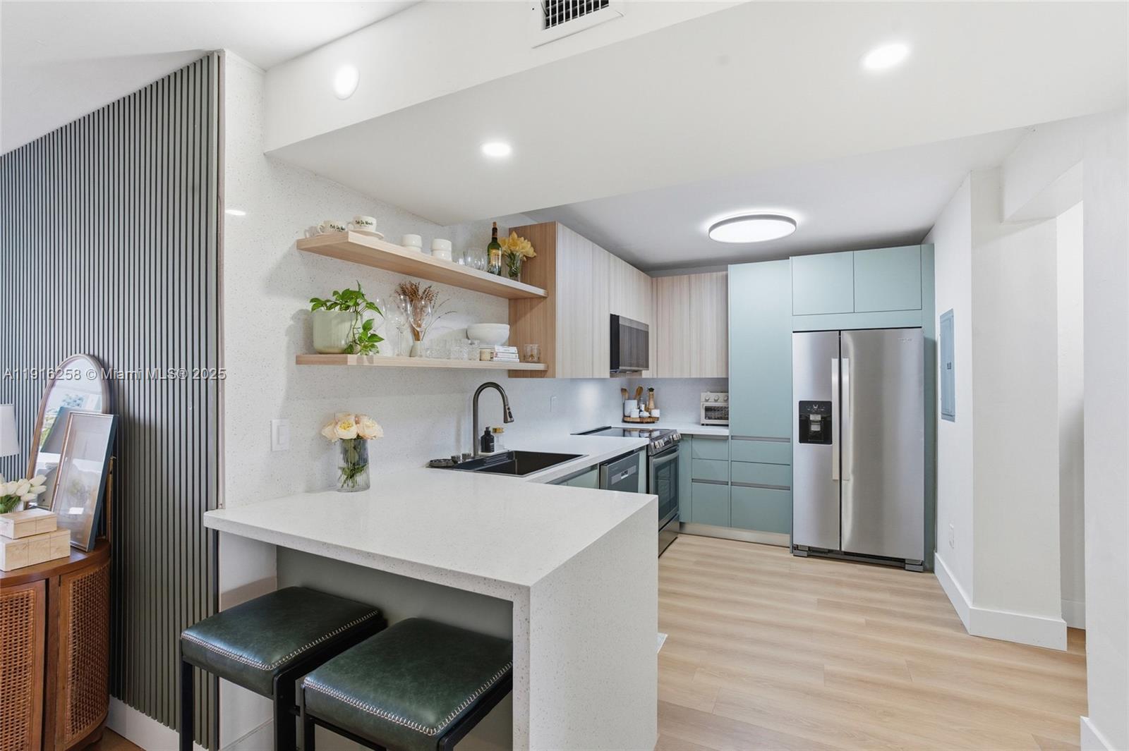 1100 11th Street, Unit 405 Miami Beach, FL 33139 - Photo 9 of 28 a kitchen with a sink cabinets and stainless steel appliances