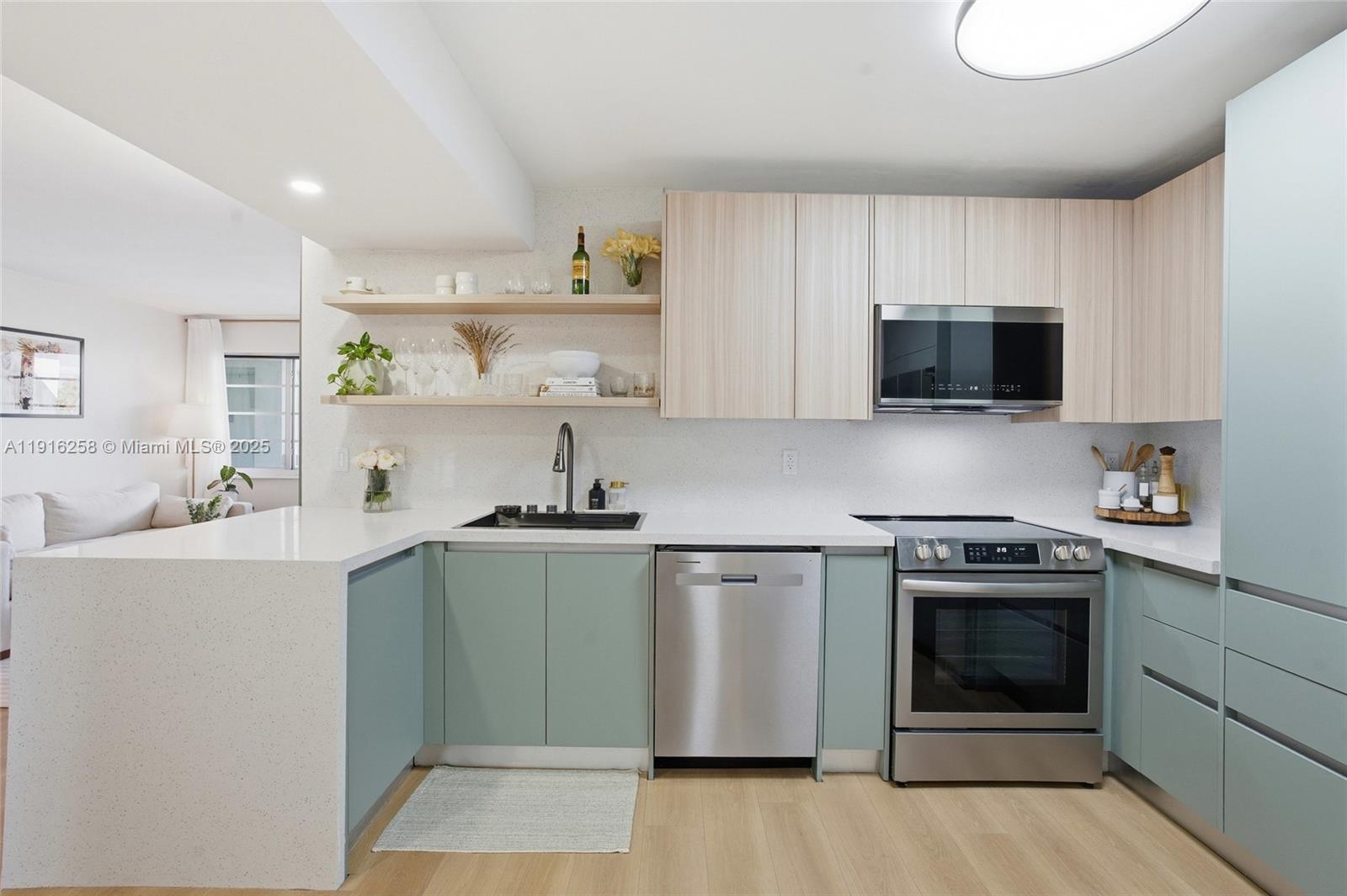 1100 11th Street, Unit 405 Miami Beach, FL 33139 - Photo 10 of 28 a kitchen with stainless steel appliances a stove a sink and a microwave
