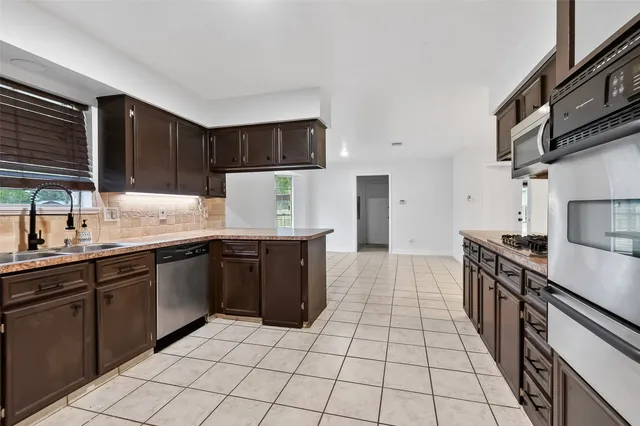 a kitchen with stainless steel appliances granite countertop a stove and a microwave