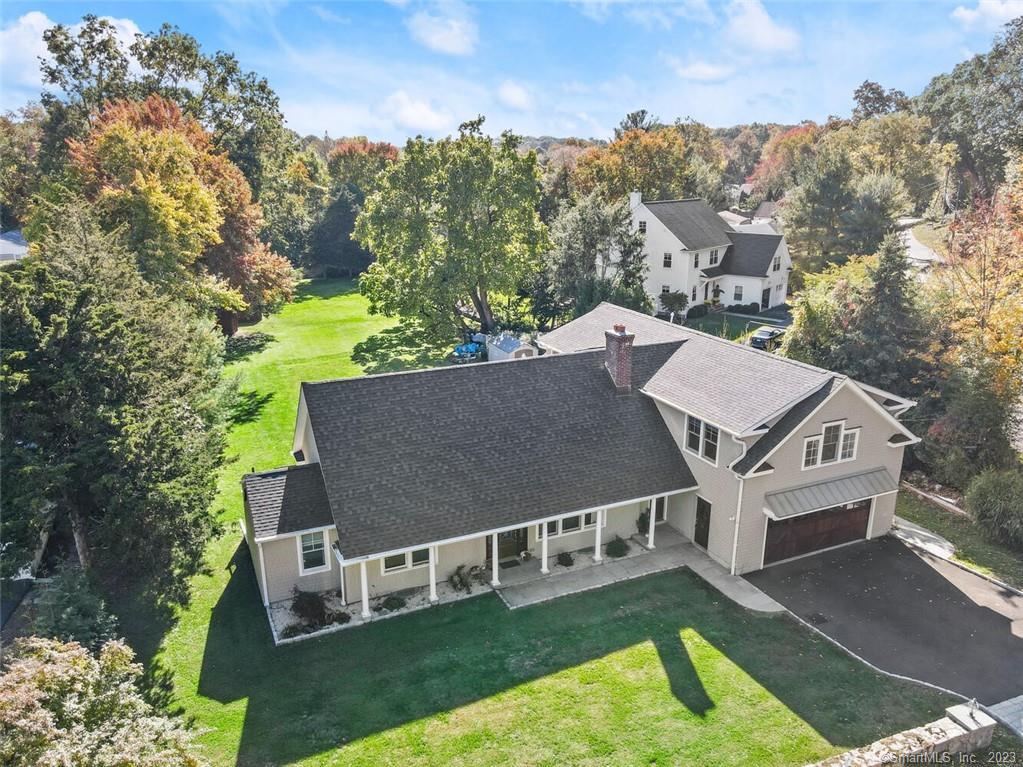 a view of a house with a big yard and large trees