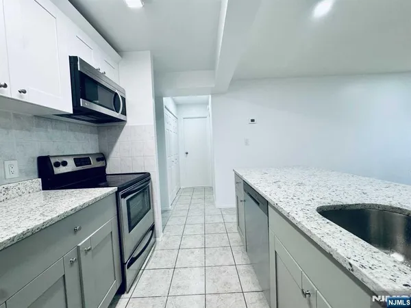 a kitchen with stainless steel appliances granite countertop a sink and a stove