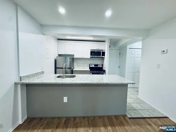 a kitchen with kitchen island a sink stainless steel appliances and cabinets