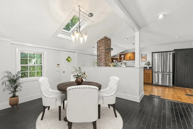 a dining room with furniture potted plants and wooden floor