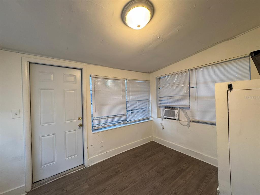 4201 Cepeda Street Orlando, FL 32811 - Photo 8 of 17 an empty room with wooden floor and windows