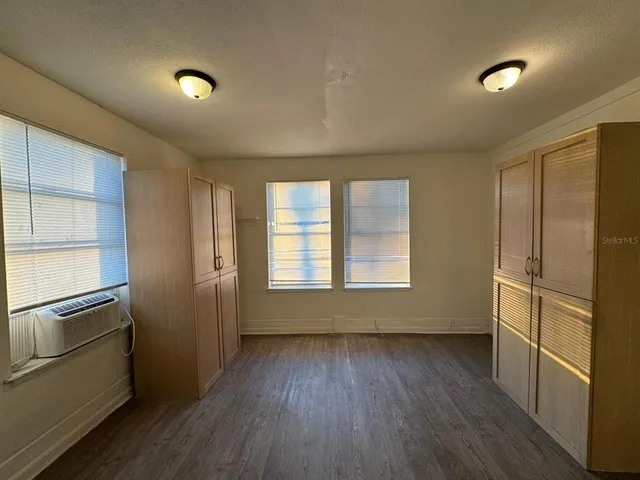 wooden floor in an empty room with a kitchen