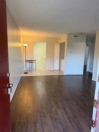 a view of a room with wooden floor and a window