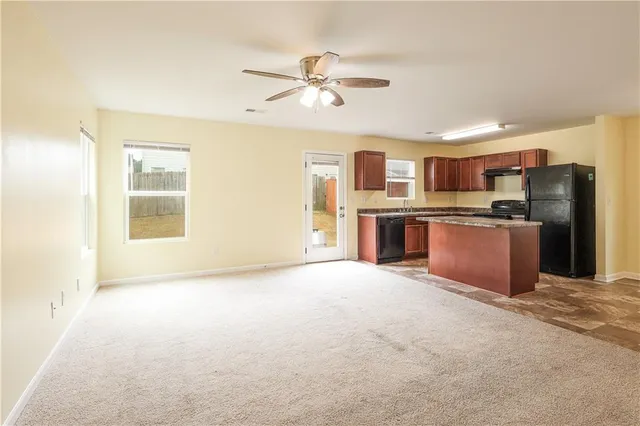 a kitchen with kitchen island granite countertop a sink stove and refrigerator