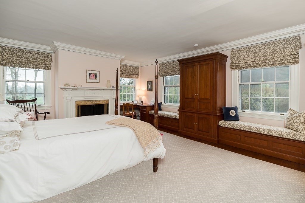 6 Jersey Lane Manchester, MA 01944 - Photo 29 of 42 a spacious bedroom with a large bed and a fireplace