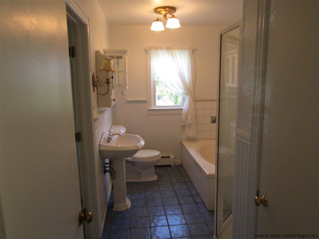 1023 Codwise Street Kingston, NY 12401 - Photo 9 of 17 a bathroom with a sink a toilet a window and shower