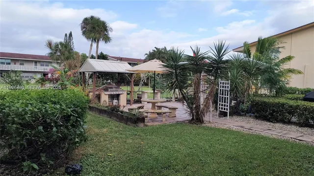 a view of a patio with table and chairs potted plants and palm tree