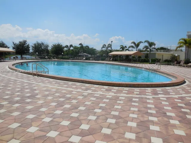 a view of a swimming pool with a yard and mountain in the back
